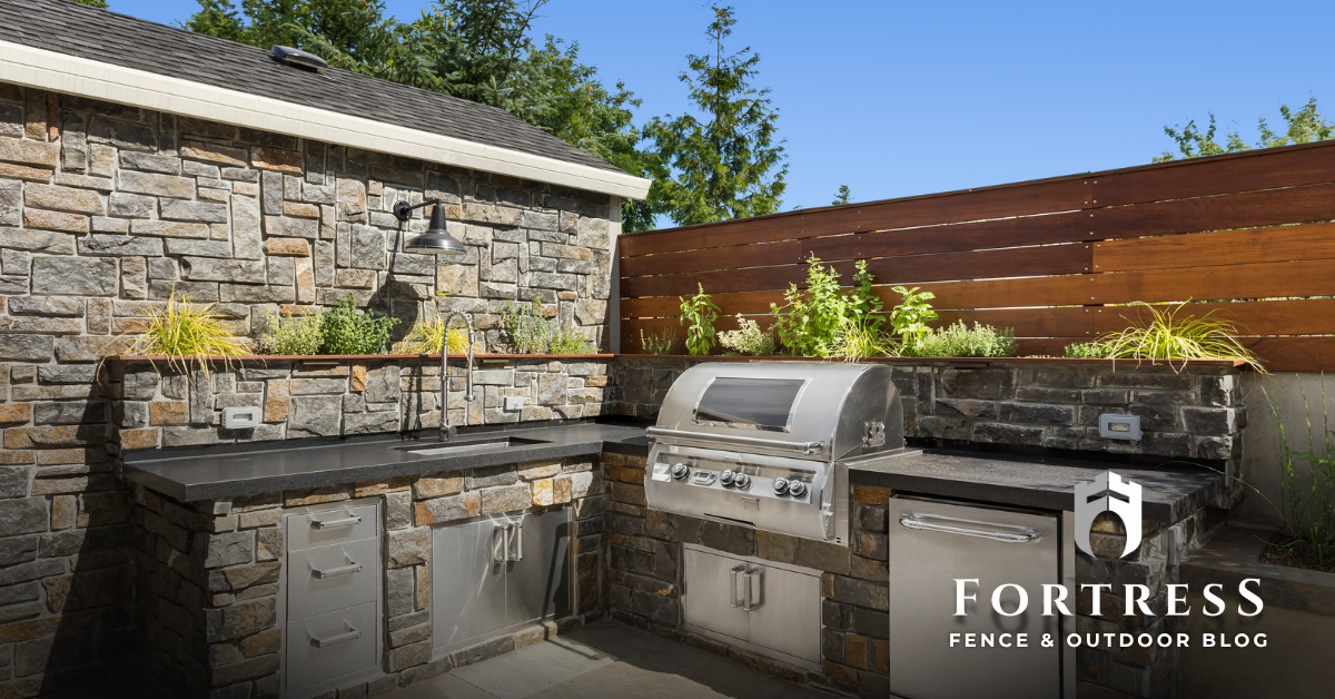 outdoor kitchen with wooden fencing trends for 2025